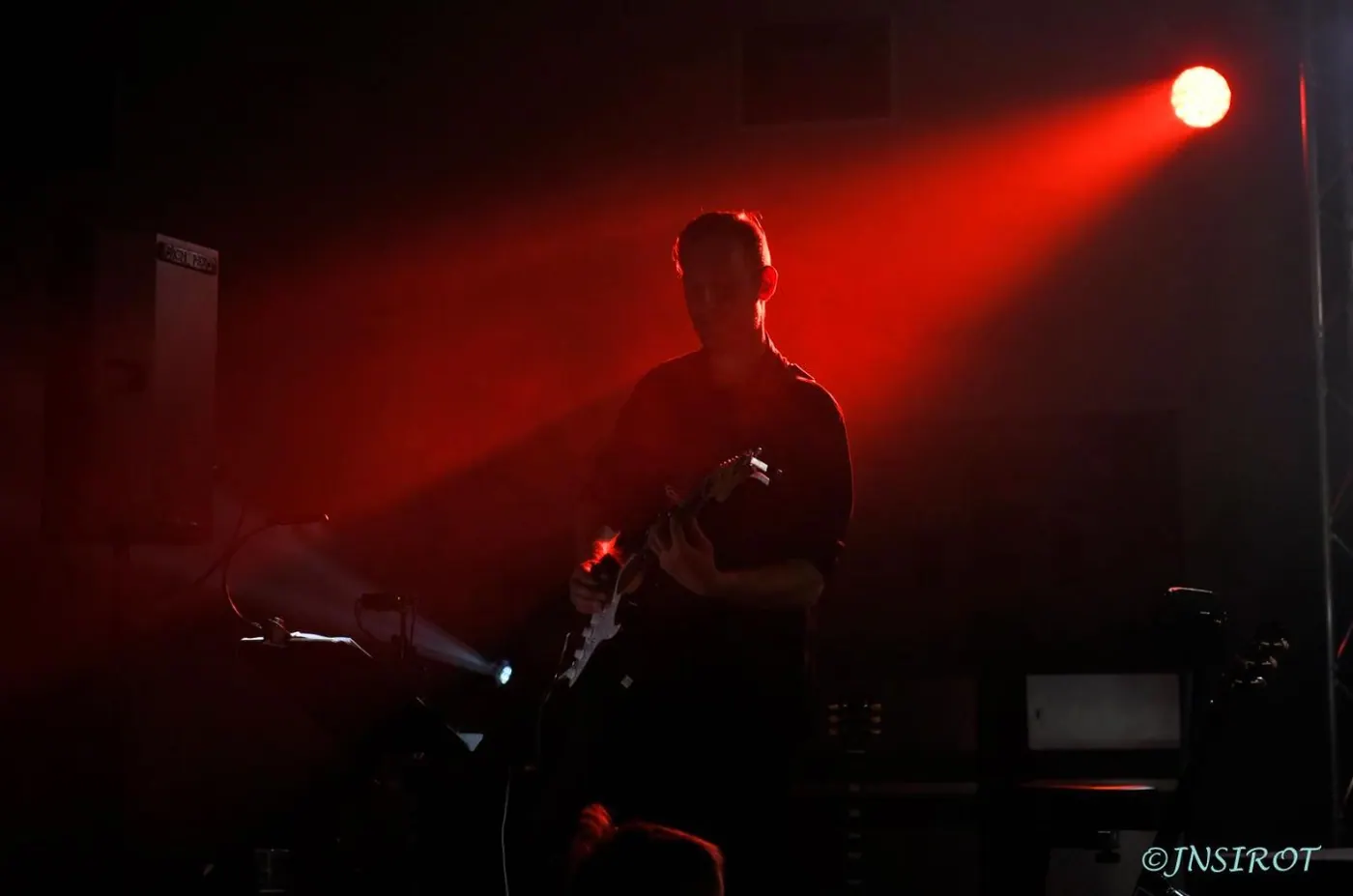 Musicien en contre-jour sous un projecteur rouge