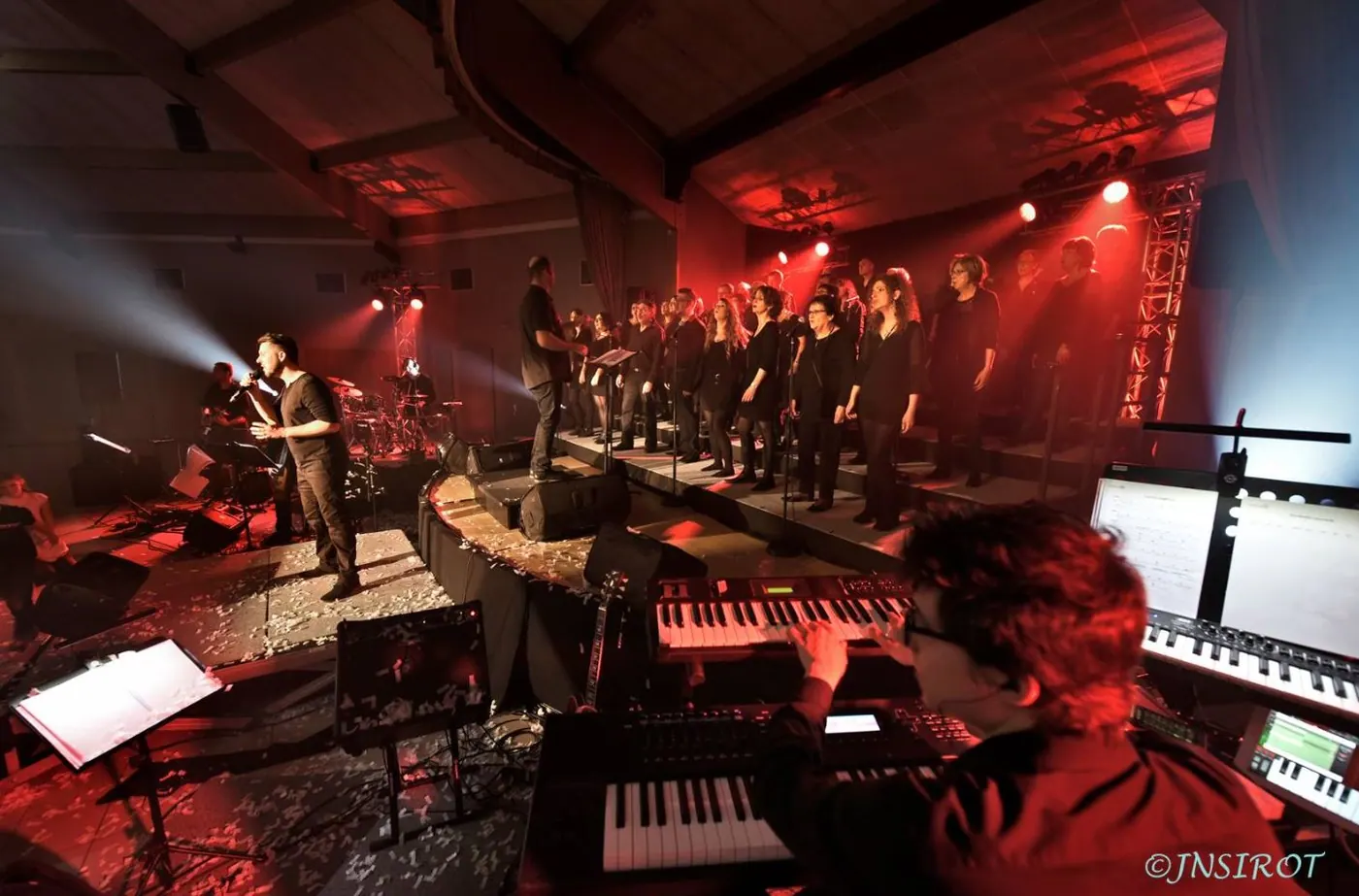 Claviers et chœur en fond de scène dans une ambiance rouge
